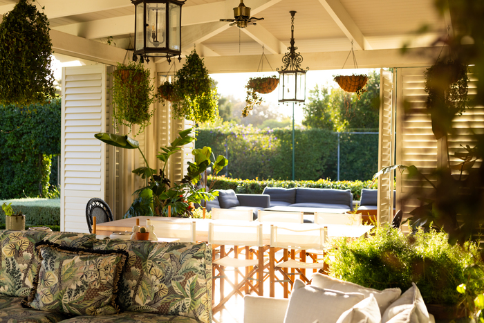 Friends gather in a covered outdoor living space, showing how a well-designed patio creates the perfect setting for entertaining family and guests.